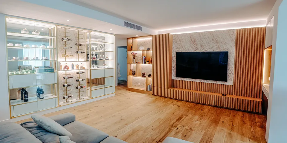 Sala de estar com vitrine iluminada e parede de televisão em ripado de madeira